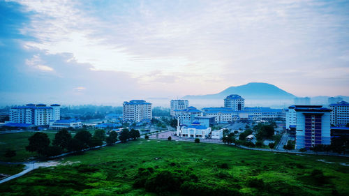 View of cityscape against cloudy sky