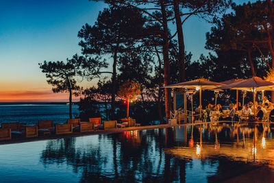 Scenic view of swimming pool against sky at sunset