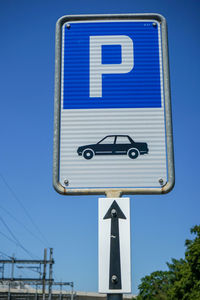 Low angle view of road sign against blue sky