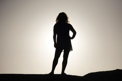 Full length of silhouette woman standing on field against sky during sunset