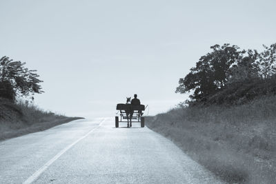 Men on road against clear sky