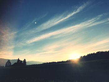 Scenic view of silhouette field against sky during sunset