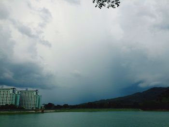 Scenic view of river against cloudy sky