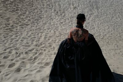 Rear view of woman standing at beach