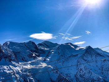 Scenic view of snowcapped mountains against blue sky