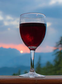 Close-up of beer glass on table against sky