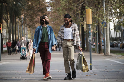 Gay couple holding hands walking on street