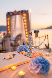 Close-up of burning candle on table