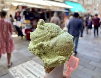 Woman holding ice cream cone in city