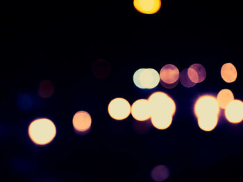 Defocused lights against sky at night