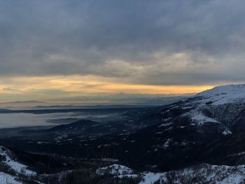 Scenic view of snowcapped mountains against sky during sunset