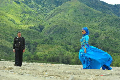 Full length of man and woman on land against mountain