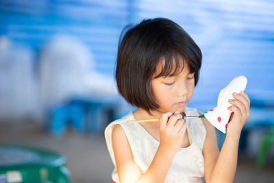 Close-up of girl painting statue