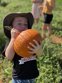 Full length of a boy holding ice cream standing on field