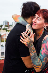 Portrait of smiling young woman hugging boy