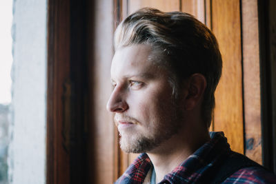 Thoughtful man against wall in winter