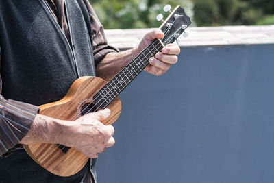 Midsection of man playing guitar