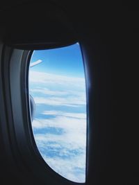 View of cloudy sky seen through airplane window