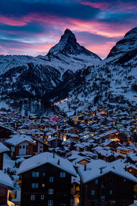 Aerial view of townscape and mountains against sky during winter