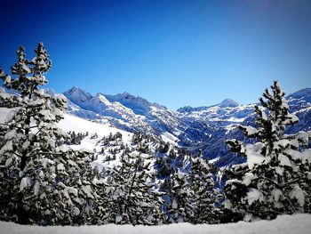 Scenic view of snowcapped mountains against clear blue sky