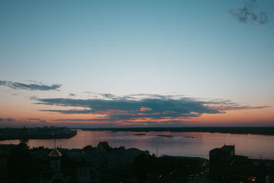 Scenic view of silhouette city against sky at sunset