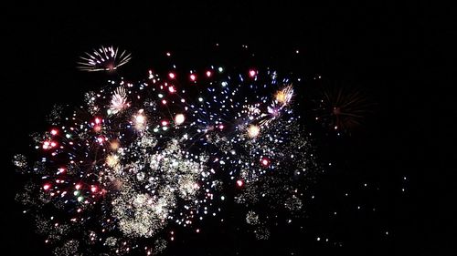 Low angle view of firework display against sky at night