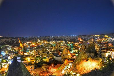 High angle view of illuminated cityscape against clear sky at night