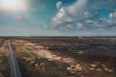 Road passing through land against sky