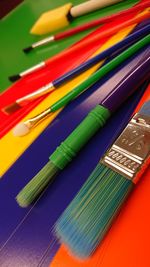 High angle view of paintbrushes on colorful table