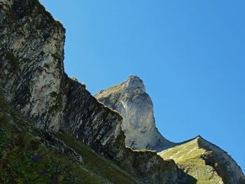 Low angle view of rocks against clear blue sky near laufbacher eck