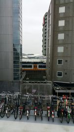 Bicycles on road in city against sky