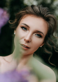 Beautiful bride in a wedding dress walks in a blooming apple-tree park in spring