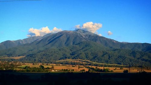 Scenic view of mountains against blue sky