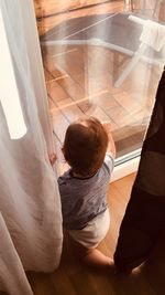 Rear view of boy on floor at home