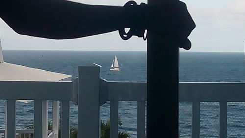 Close-up of metal by sea against sky