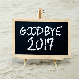 Close-up of goodbye 2017 on blackboard at beach