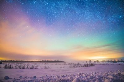 Scenic view of snow covered field against sky at night