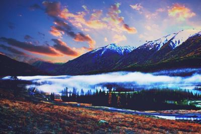 Scenic view of snowcapped mountains against dramatic sky