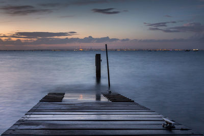 Pier over sea against sky during sunset