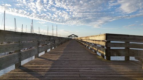 Footbridge over pier against sky
