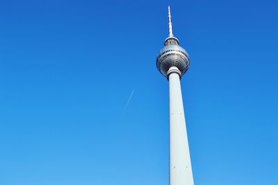 Low angle view of communications tower against blue sky