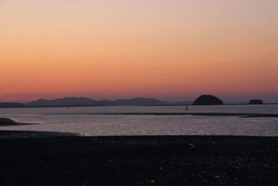 Scenic view of sea against orange sky