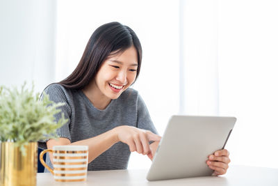 Smiling young woman using mobile phone