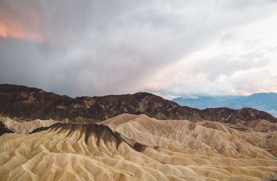 Scenic view of desert against cloudy sky