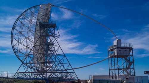 Low angle view of ferris wheel against blue sky