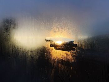Wet car on illuminated street during rainy season