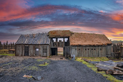 Traditional wooden house in viking village against dramatic sky during sunset