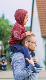 Father walking with his son sitting on his shoulders