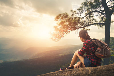 Woman sitting on mountain looking at view