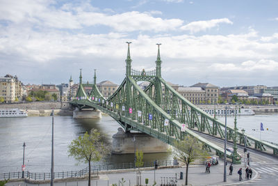 Bridge over river against cloudy sky